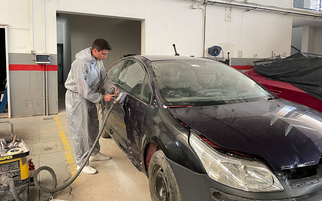 Un alumno de Automoción del CPIFP Bajo Aragón realiza trabajos de reparación y pintura en un coche./ María Celiméndiz