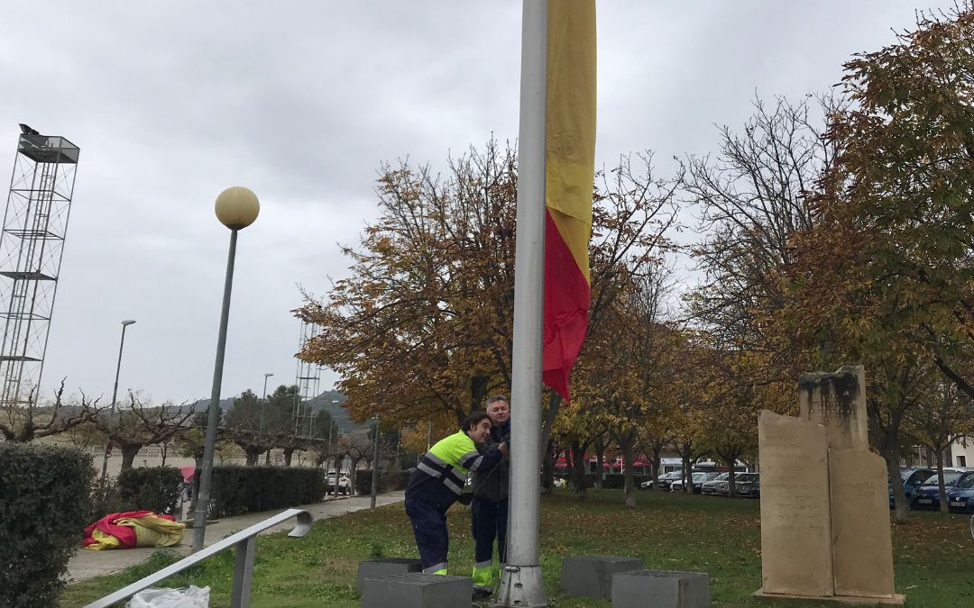 Operarios de la brigada colocando ayer la nueva bandera de la plaza Constitución de Alcañiz como parte de los preparativos./ C. O.