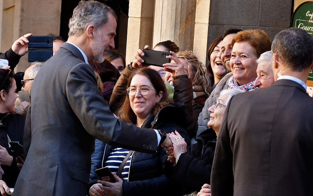 El monarca estrecha la mano a una vecina mayor que estaba entre el público./ L.C.