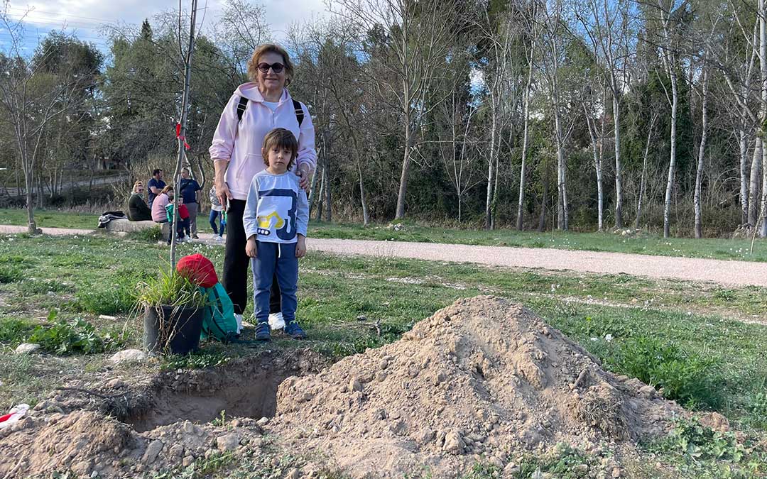 Abuela y nieto plantan uno de los ejemplares en la ribera./ M.C.