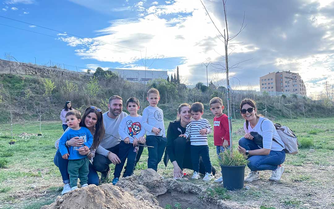 Un grupo de padres con sus hijos colaboran en la plantación de latoneros en la ribera del río Guadalope en Alcañiz./ María Celiméndiz