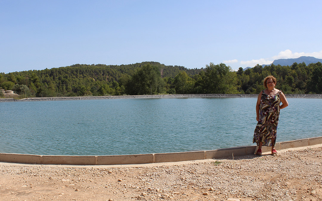 María Teresa Crivillé, alcaldesa de Lledó, muestra la nueva balsa llena./Raúl Belver.
