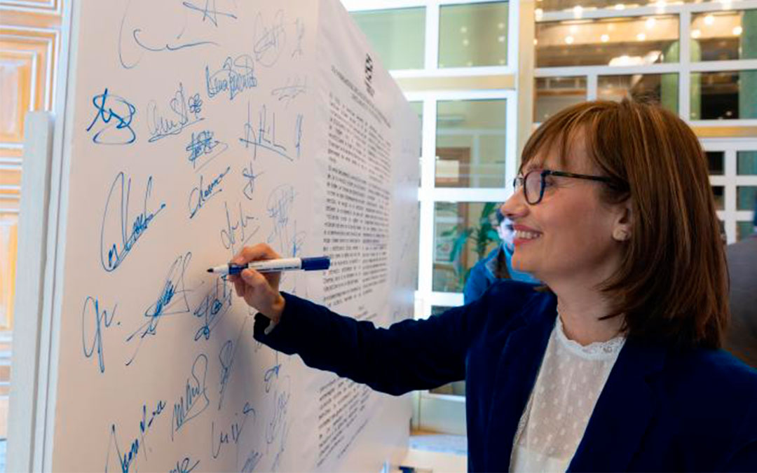 María Antoñanzas firma en el mural del manifiesto./ Fabian Simon