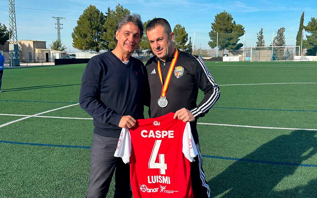 Michel López, padre de Luismi, junto a Javi Romero, entrenador del C.D. Caspe, tras la entrega de la camiseta a la familia. / Twitter @InigoGarriga