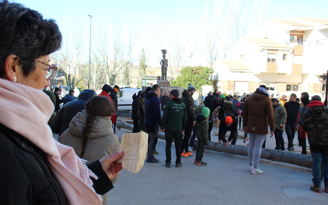 Delia Ínsa sostiene la astilla procedente del álamo de la Monumental que su nieto se guarda de recuerdo mientras él tira de cuerda en la plantada del chopo en el Puente. / B. Severino