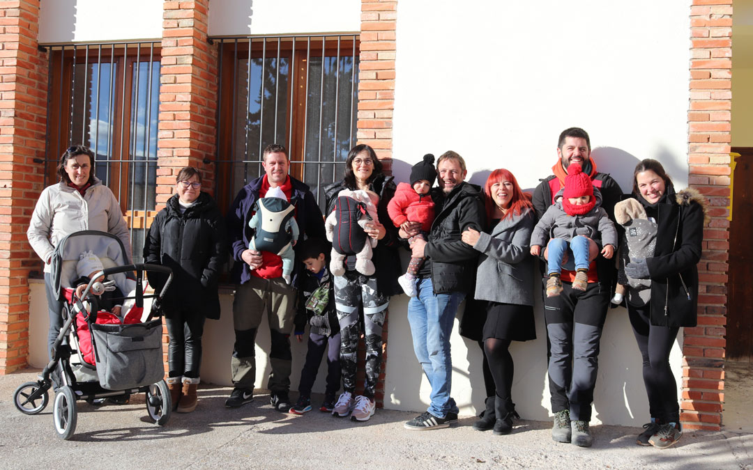 Las cinco familias posan sonrientes a las puertas de la antigua escuela, edificio donde muchos impartieron clases antes de su cierre hace veintidos años y que será reabierto como escuela infantil. /N.A.