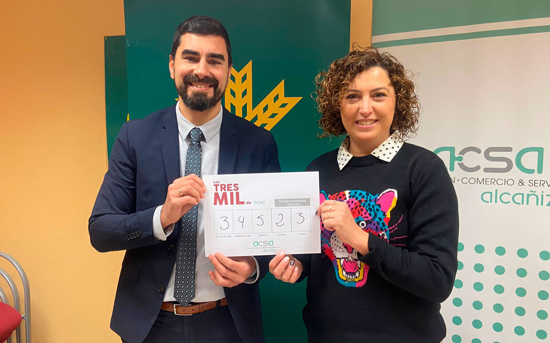 Carlos Pellicer, director de la oficina principal de Caja Rural en Alcañiz e Irene Quintana, gerente de ACSA, muestran el número./ M.M.R.