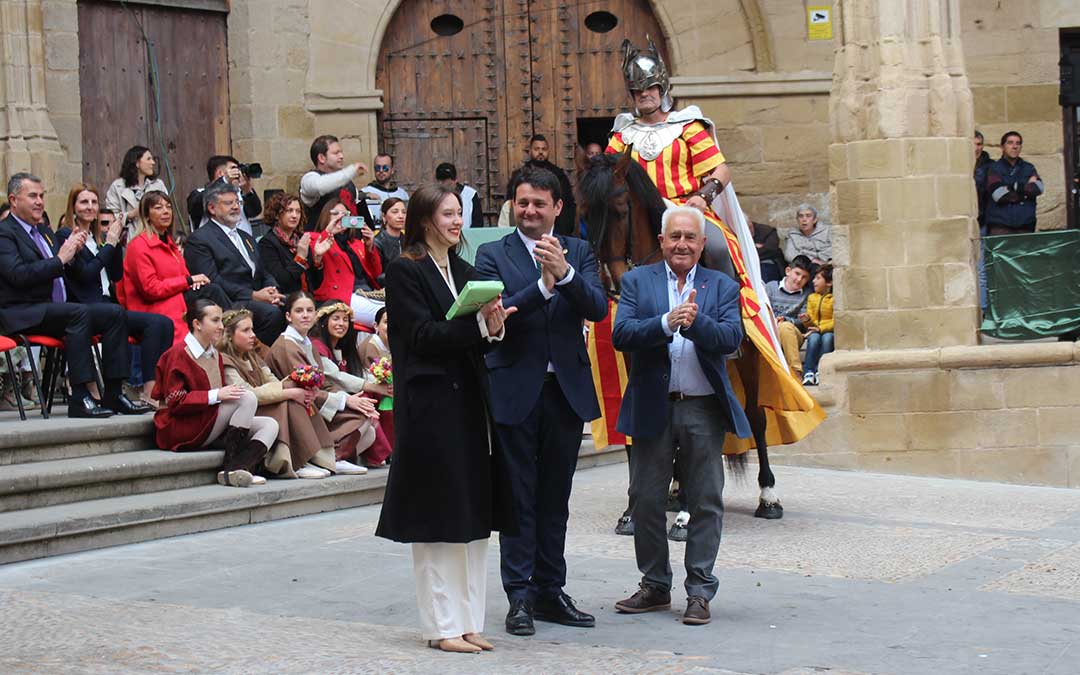 Iris Pérez recibiendo el ejemplar de El Quijote de manos del alcalde y junto a Juan Pardo / L. Castel