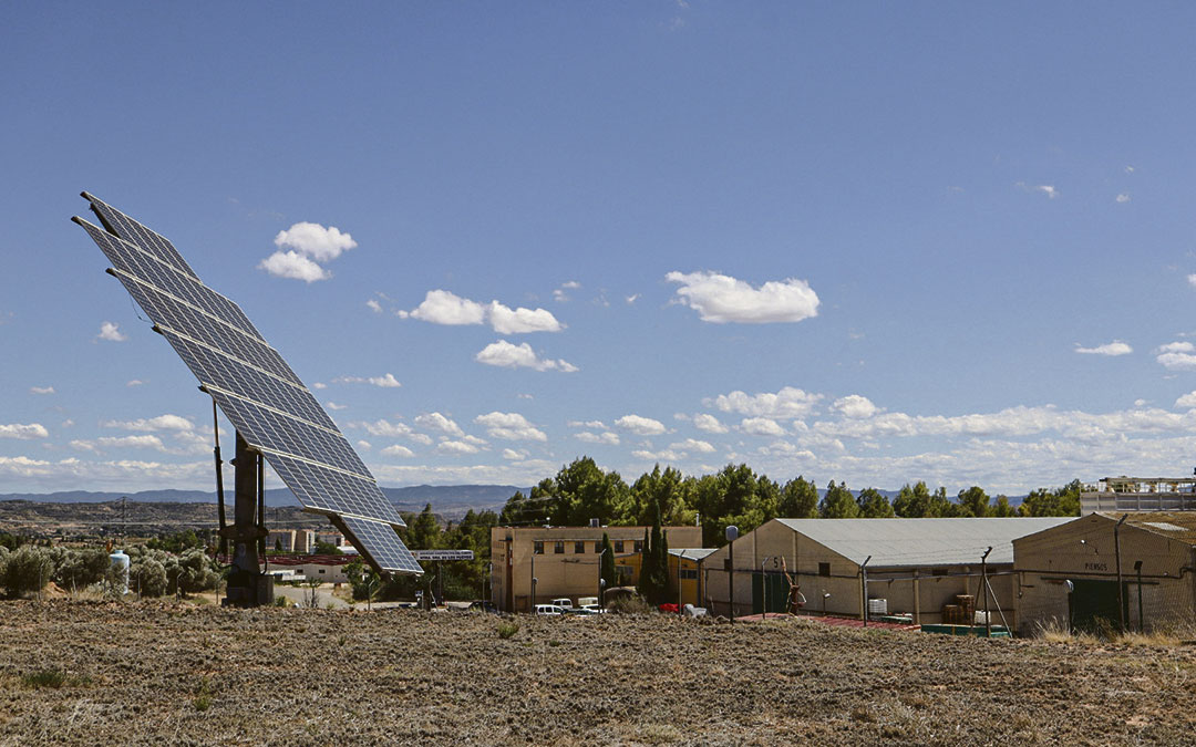 La cooperativa Nuestra Señora de los Pueyos de Alcañiz (al fondo) instaló en el año 2008 placas solares en una finca al lado de la misma./ A.Z