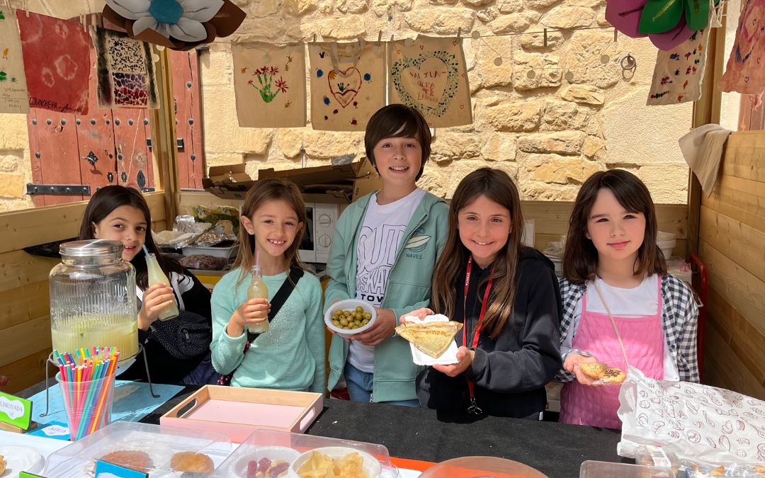 Los más pequeños del pueblo junto a sus creaciones culinarias en el puesto del Ampa./ C.O.