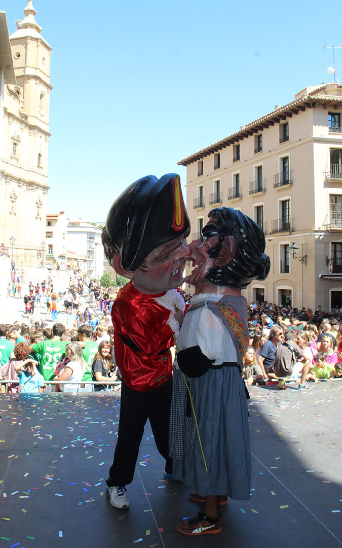 También los cabezudos se dieron sus besos en el Lanzamiento de caramelos en el chupinazo de las fiestas de Alcañiz 2024. / B. Severino