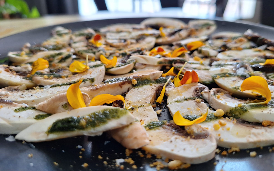 Carpaccio de champiñones aliñado con albahaca, kikos y lima