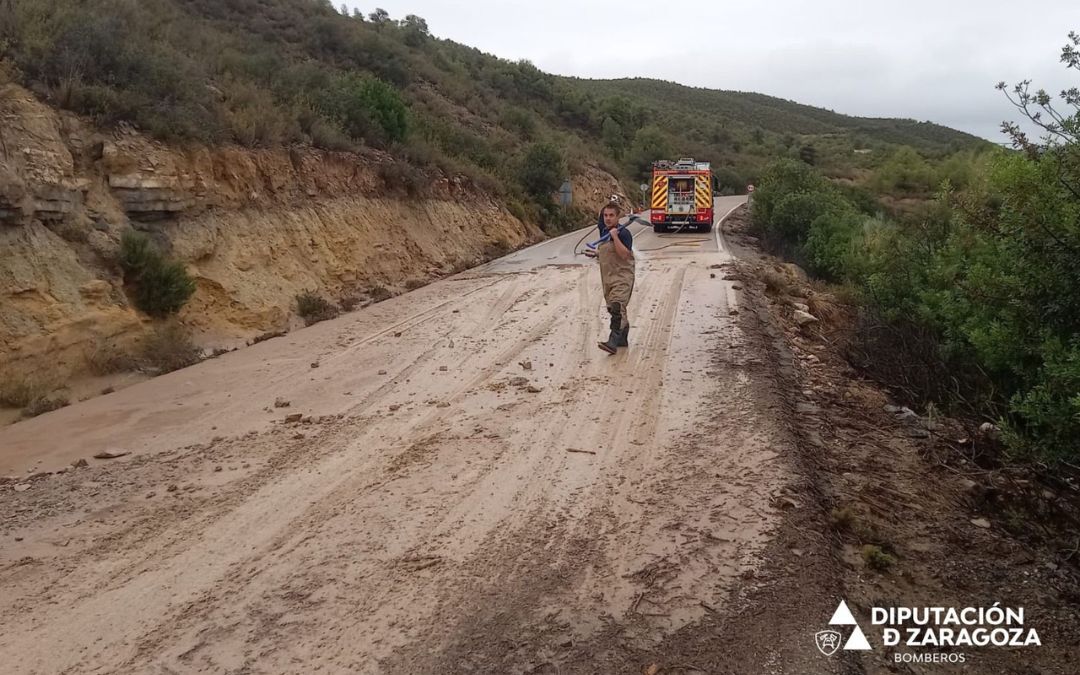 Bomberos de la Diputación de Zaragoza realizando labores de limpieza en la carretera CV-103, en el acceso a Fayón./ DPZ