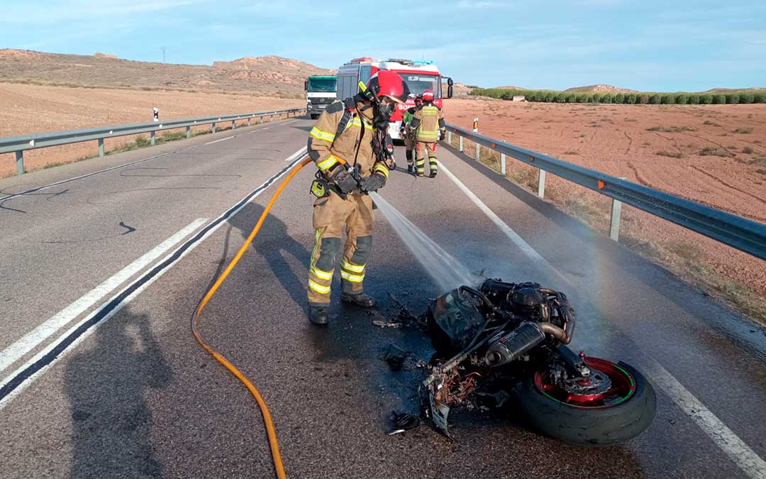 Un bombero sofocando el incendio de la moto./ DPT