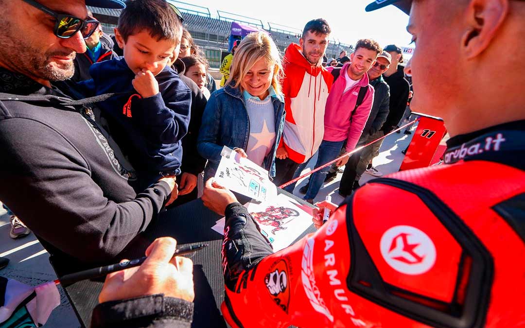 Imagen de Adrián Huertas firmando autógrafos en el Pit Lane Walk de la Tissot Aragón Round./ Motorland.