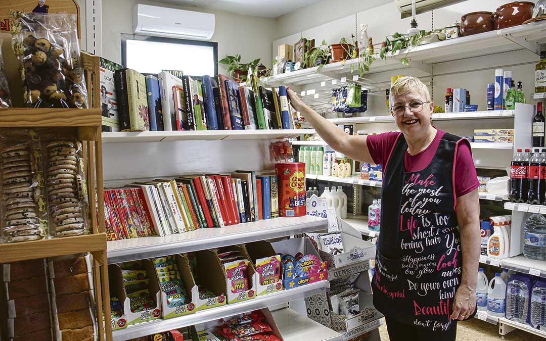 Conchi Ronquillo en el punto de intercambio de libros que tiene en la tienda del multiservicio en Azaila, y que surgió por iniciativa popular. / B. Severino