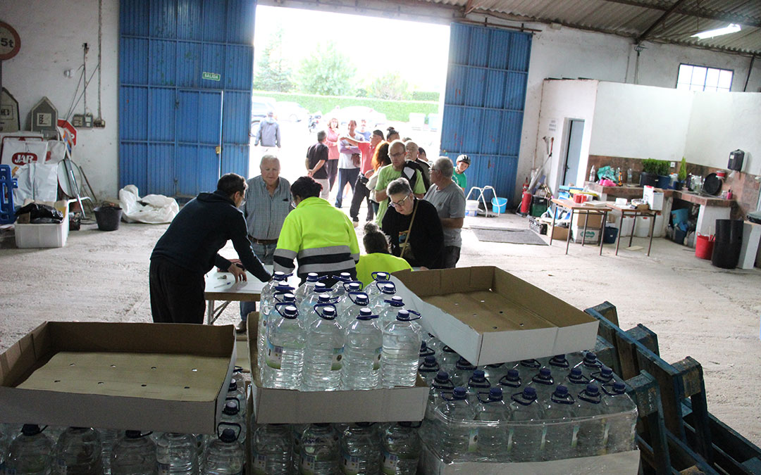Reparto la tarde del martes en La Puebla de Híjar del agua del primer camión y de los palets comprados propios. / B. Severino