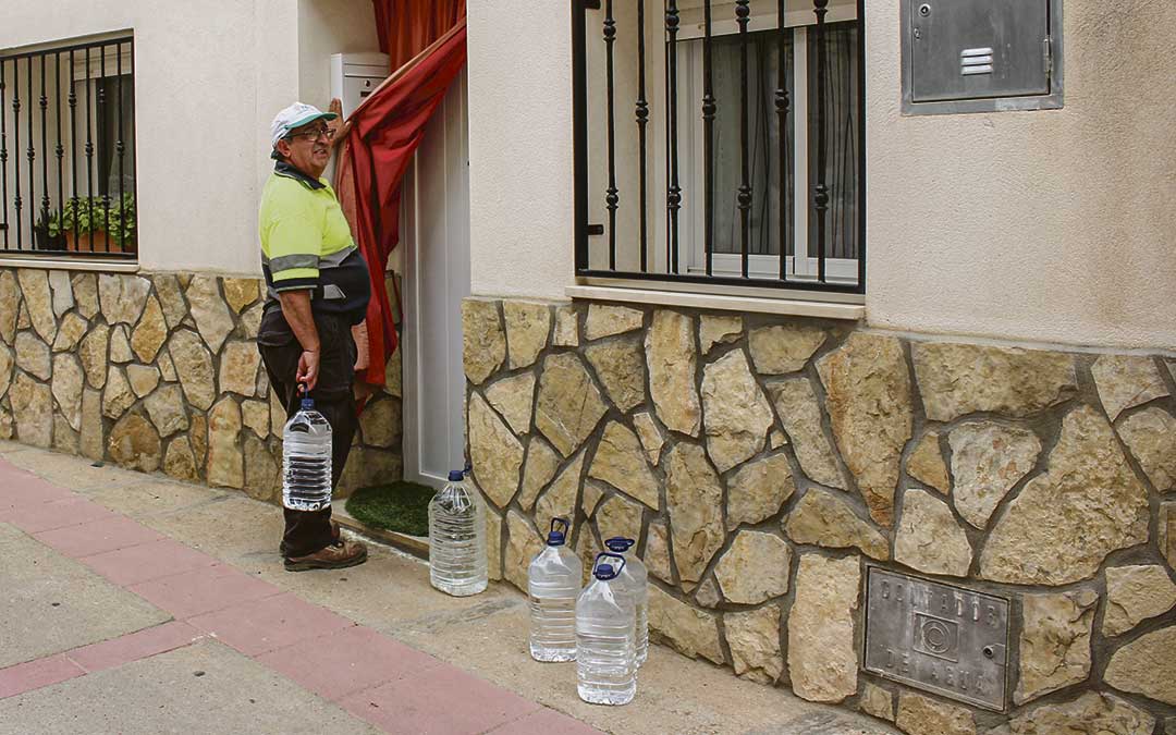 Un operario de la brigada de Samper repartiendo agua a domicilio. / L. Castel
