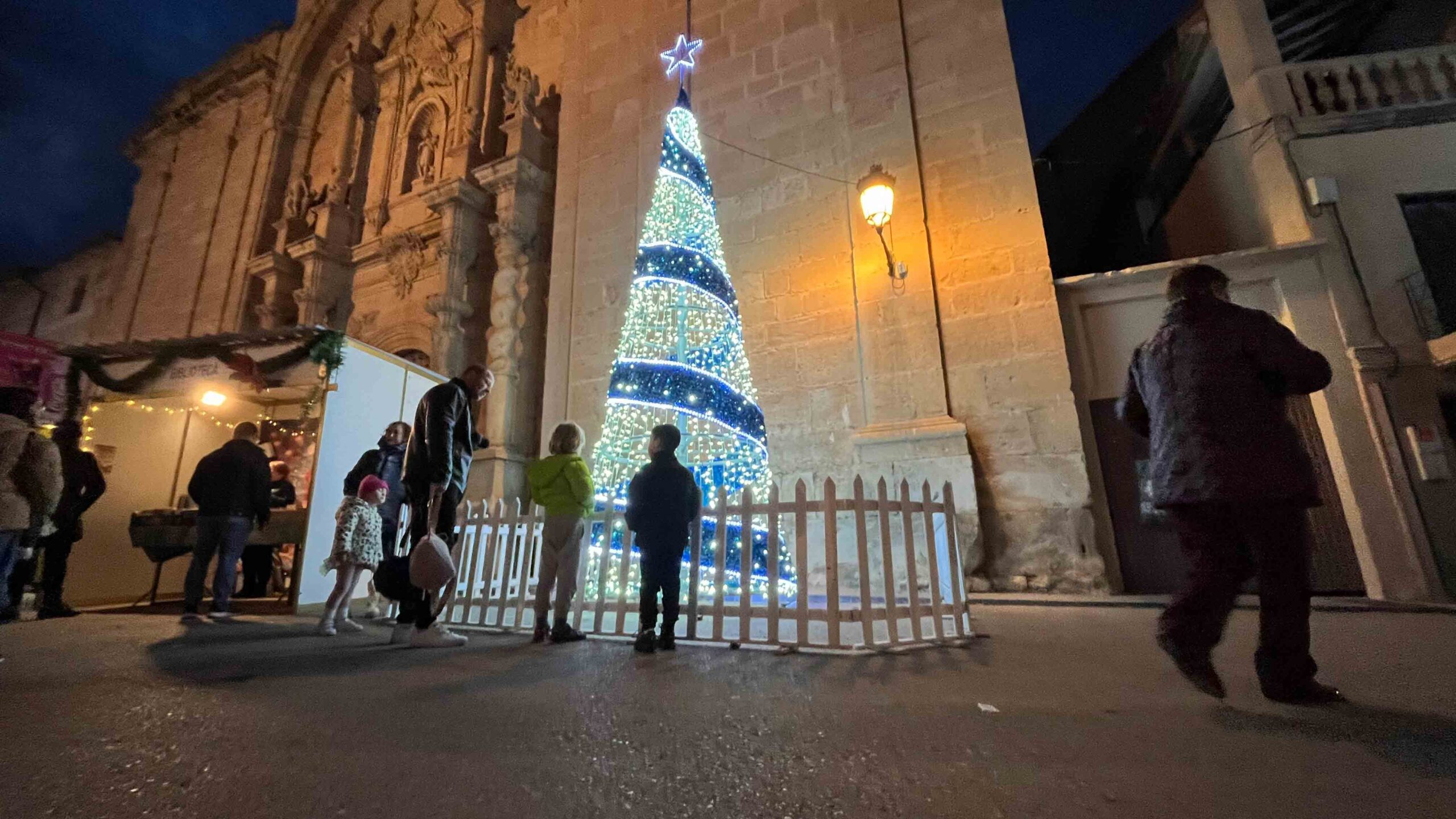 El gran árbol luminoso, instalado frente a la iglesia, se convirtió en el centro de todas las miradas tras el esperado encendido, que marcó el inicio de las fiestas./ La COMARCA