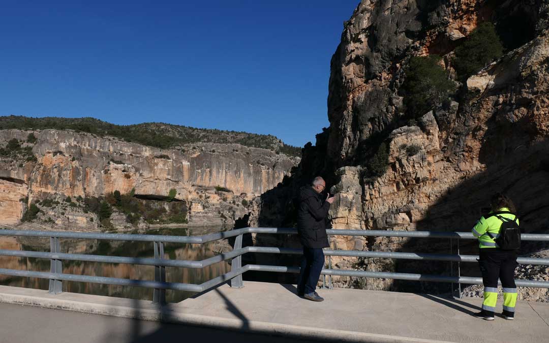 Dos personas fotografía el estado del embalse desde la presa./ M.M.R.