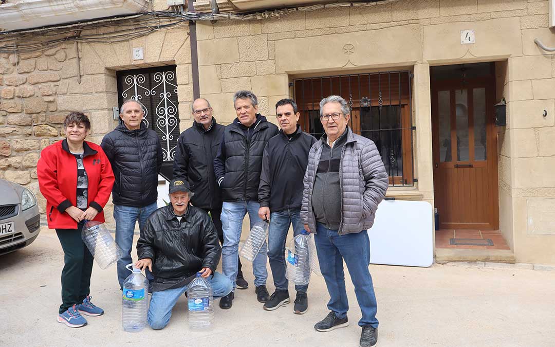 Grupo de vecinos esperando al camión de bomberos para coger agua potable en Valdealgorfa. / Alba Zurita