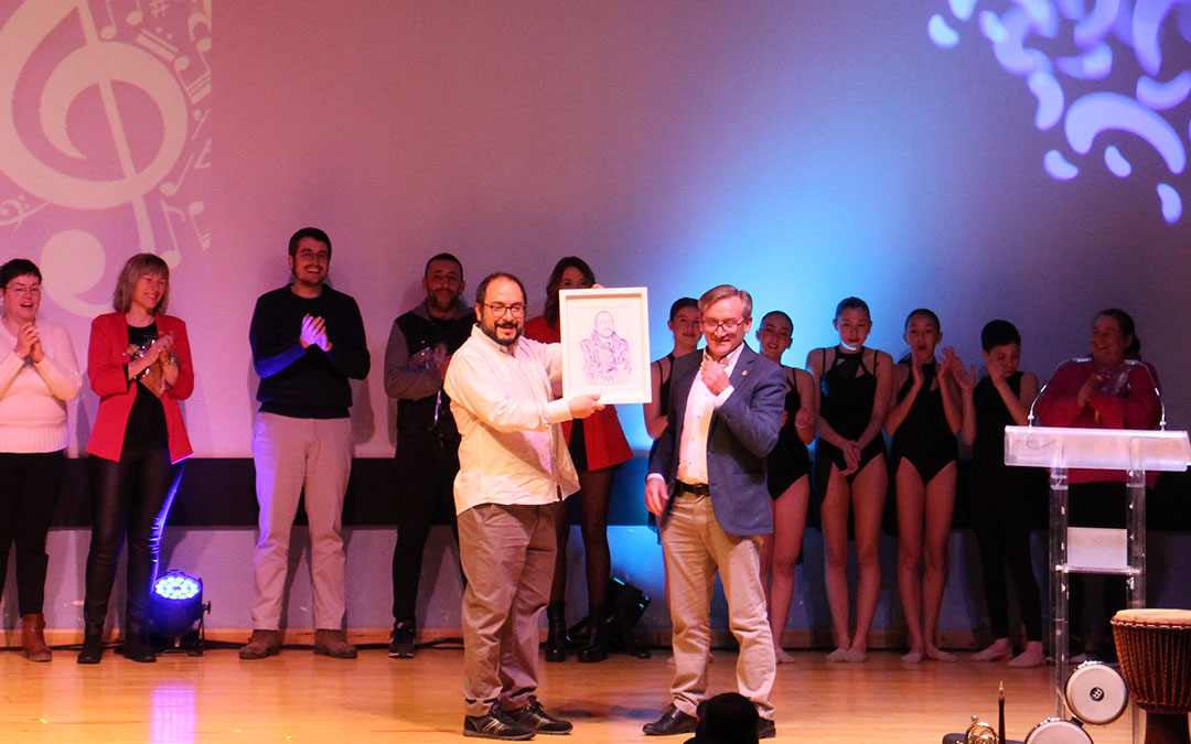 El director de la banda de música Víctor Monzón recibió un homenaje que le entregó el presidente de la DPT Joaquín Juste. / B. Severino