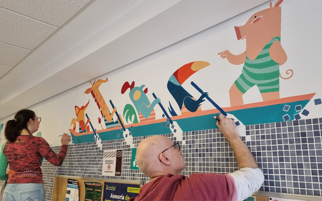 El artista David Guirao (a la derecha) es el artífice del mural de la sala de espera de pediatría del centro de salud de Alcañiz./ Believe in Art