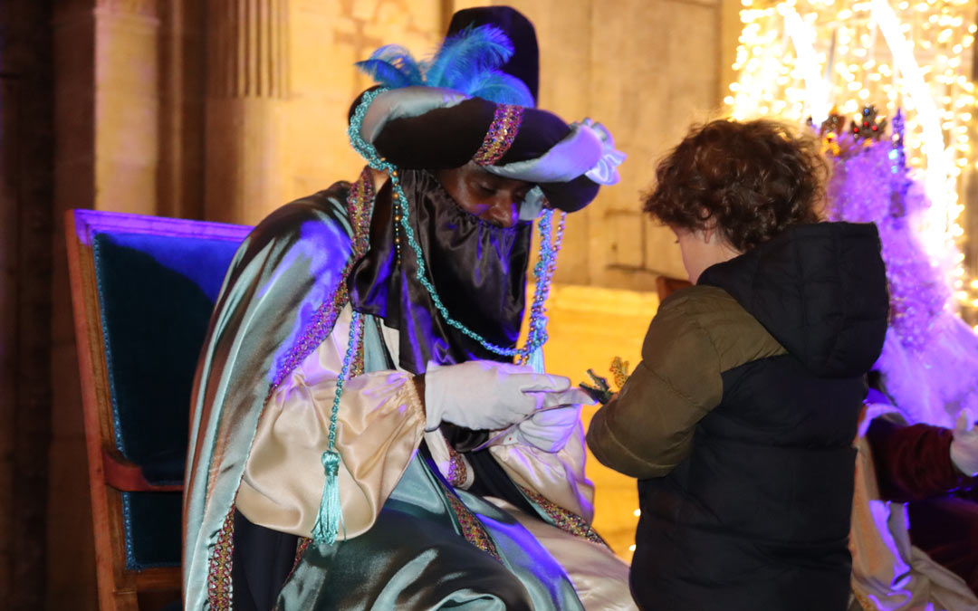 Baltasar recibiendo una carta y unos juguetes de un niño en la Plaza España./ Sandra Jiménez
