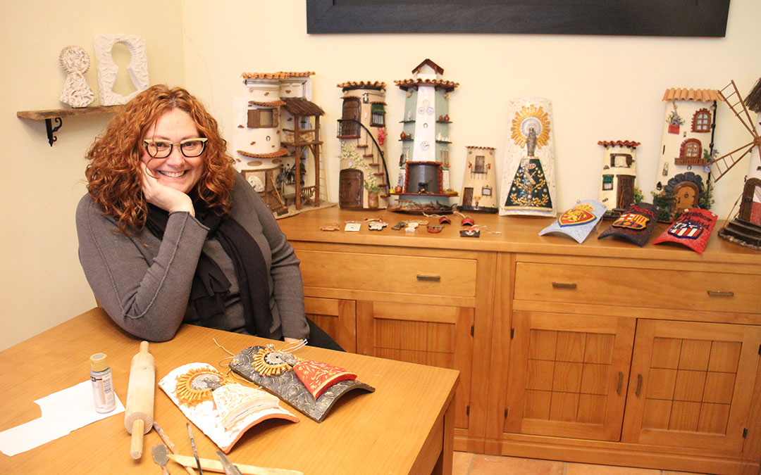 Yolanda Valle, en Oliete, en casa de una de sus hermanas con una muestra de sus tejas. La mayoría tienen dueño pero las recopiló para la ocasión. Junto a ella, sus herramientas y una teja con la Virgen del Pilar en proceso y otra acabada. / B. Severino