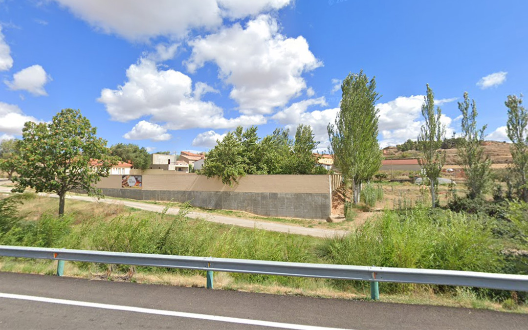 El almacén municipal se construirá en un terreno contiguo a las piscinas, junto a la N-211./ Google Maps