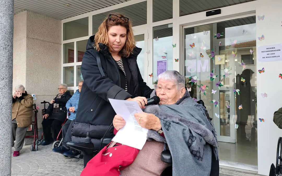 La alcaldesa, María Ariño, sostiene el micrófono a Nieves García en la lectura de su poema en el 8M de Mas de las Matas. / Ayto. Mas de las Matas