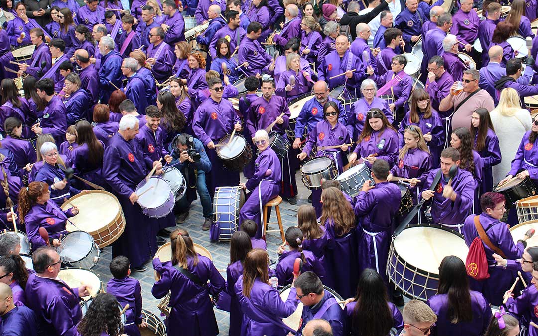 Parada del toque en Calanda 2025. Entre la multitud, César Gracia, fotógrafo incansable que se escurre entre la multitud con su banqueta para subirse y elevarse. Cuando no la emplea, siempre hay alguien que le da uso por unos segundos. / B. Severino