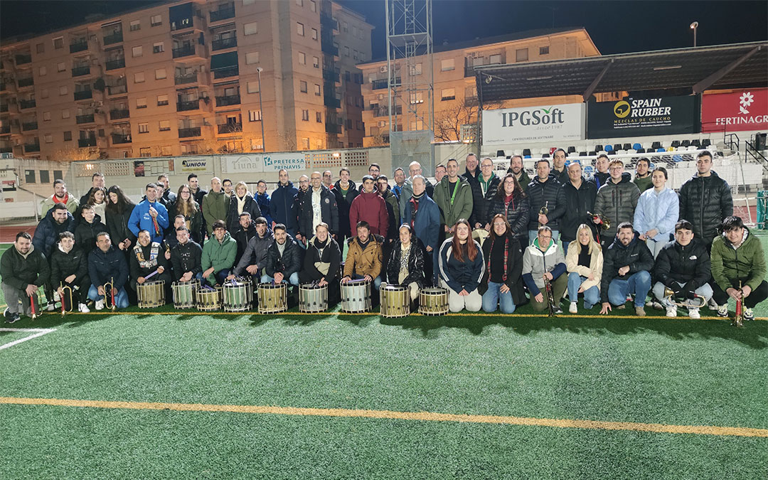 Foto de familia de parte de la Hermandad Jesús Nazareno de Alcañiz. Posan en el campo de fútbol, donde suelen ensayar y tratan de retransmitirlo por sus redes sociales para llegar a «todos los hermanos». / Alberto Gracia