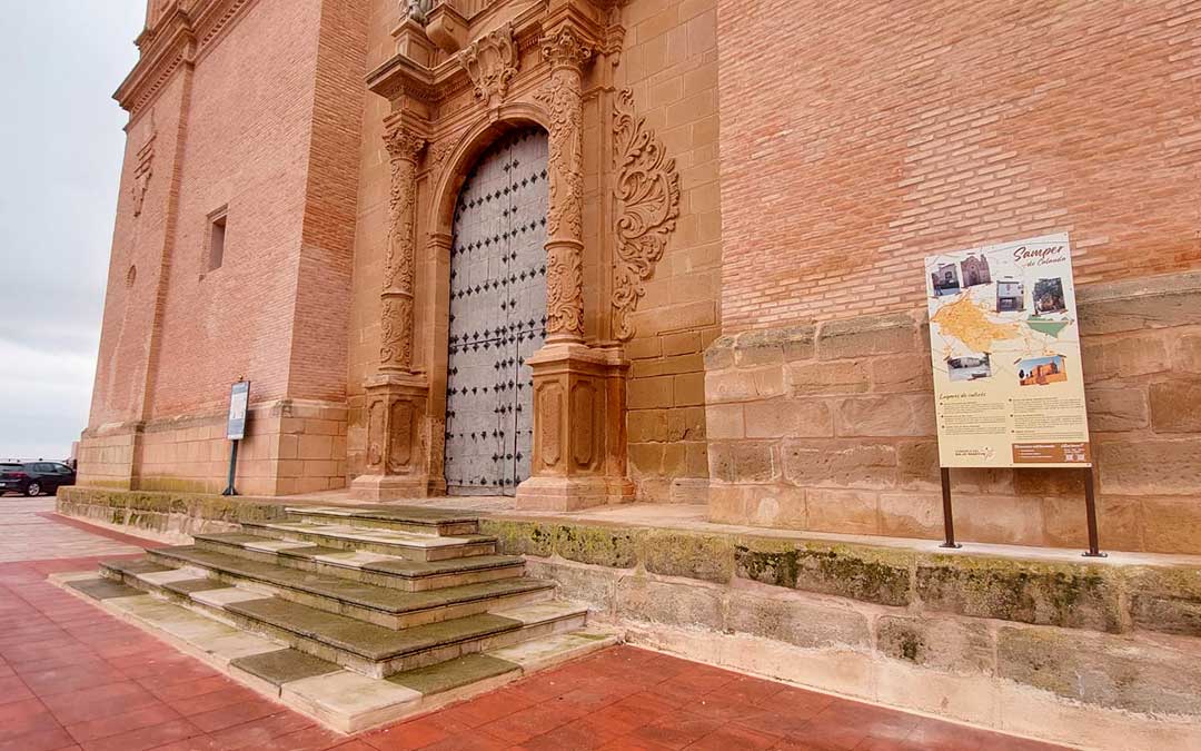 Panel informativo con lugares de interés y mapa junto a la fachada de la iglesia de Samper. / Comarca del Bajo Martín