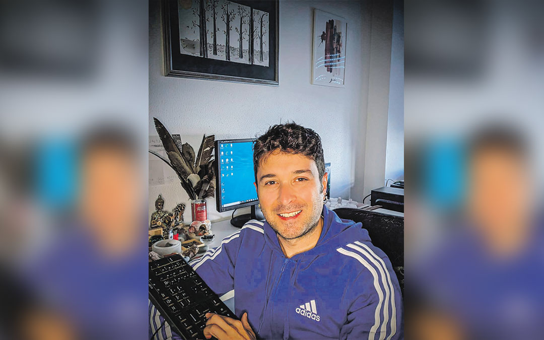 Adrián Fontoba Ribó, en su estudio donde escribe rodeado de energía a través de varias piedras apropiadas. Sobre el ordenador, un cuadro de Eva Ricart. / Archivo personal
