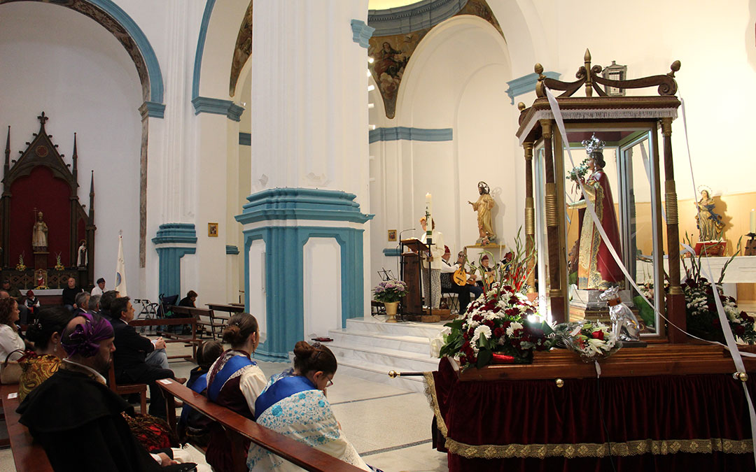 Santa Quiteria presidió la misa con las flores de oferentes en la peana. / B. Severino