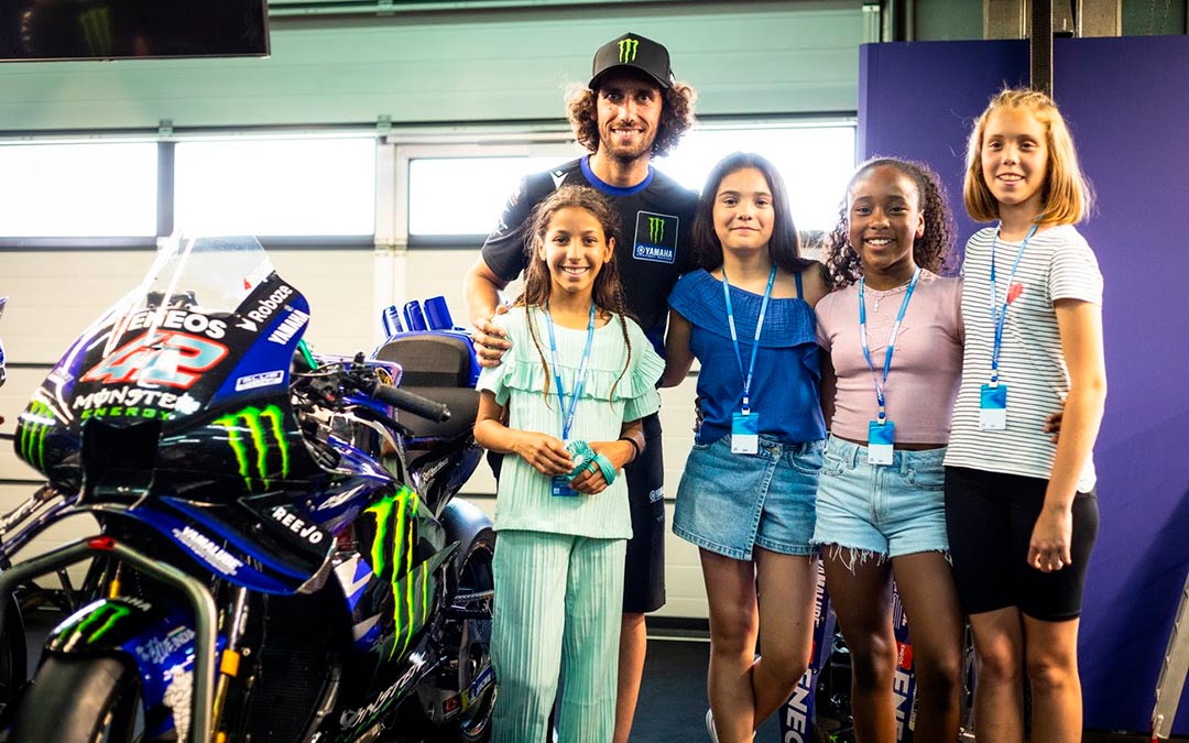 Imagen de Álex Rins junto a las ganadoras del concurso de 2025./ Motorland.