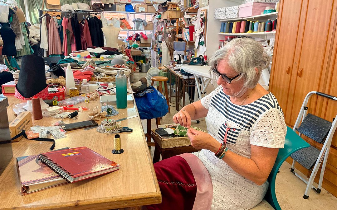 Inmaculada Bayo rematando una capelina, en el taller de confección./ S.F.