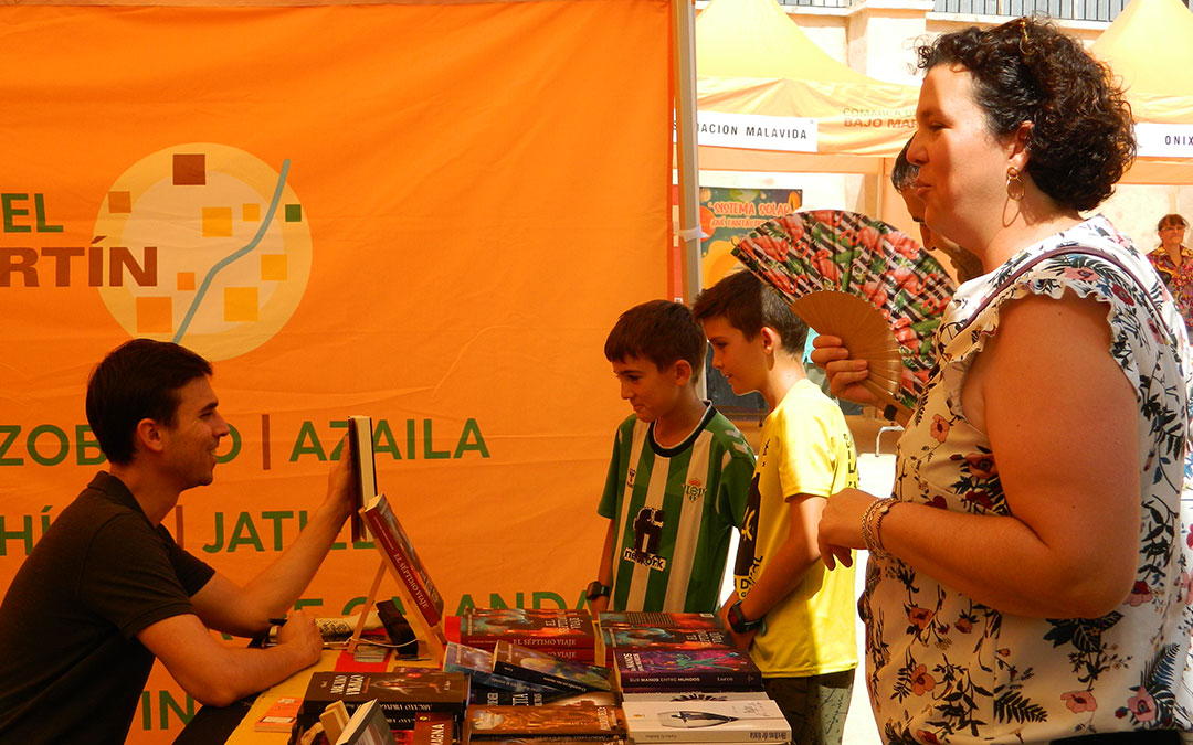 El autor Guillermo Romero recibe a los visitantes en la Feria del Libro de Jatiel. / S.C