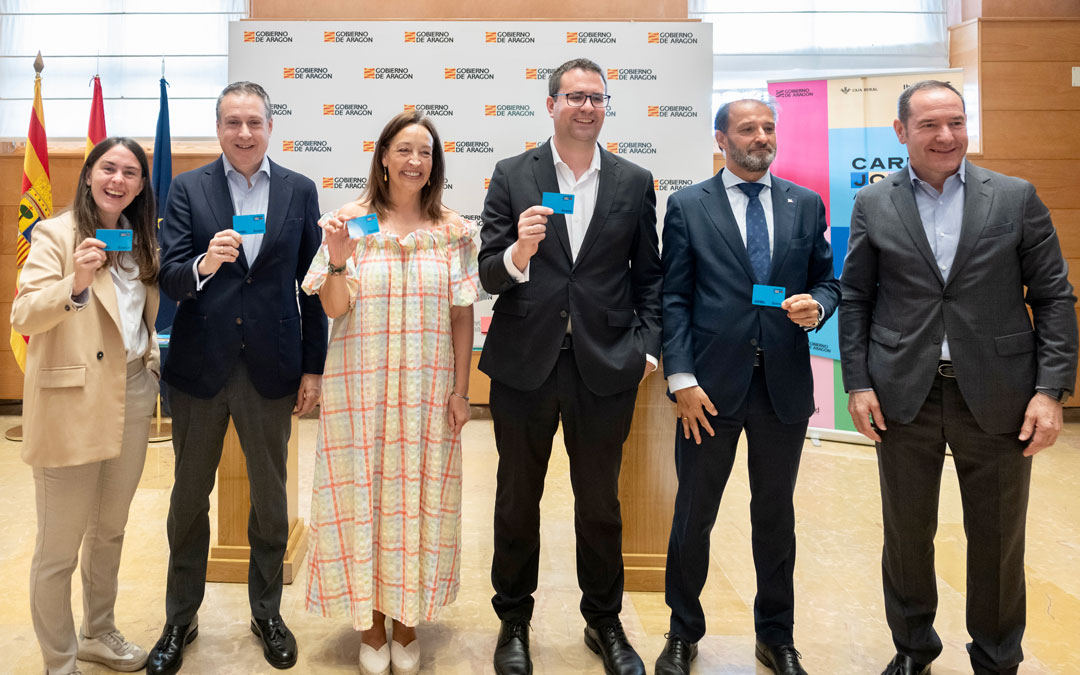 En la imagen, la consejera Susín y la directora general del IAJ, Cristina Navarro, con los representantes de las tres entidades financieras./ DGA