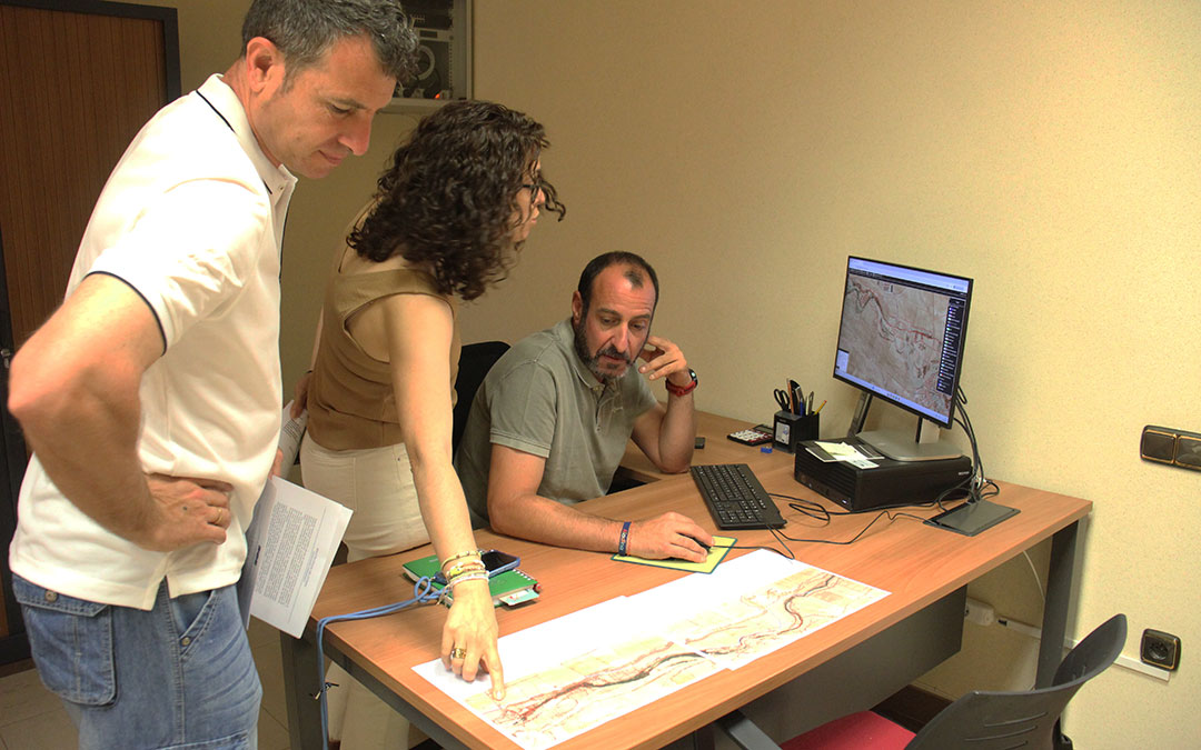 El alcalde, Luis Ezquerra, sentado al ordenador; la secretaria, Beatriz Úbeda; y el teniente de alcalde, Álvaro Segundo, imprimiendo planos del recorrido de la tubería rota. / B. Severino