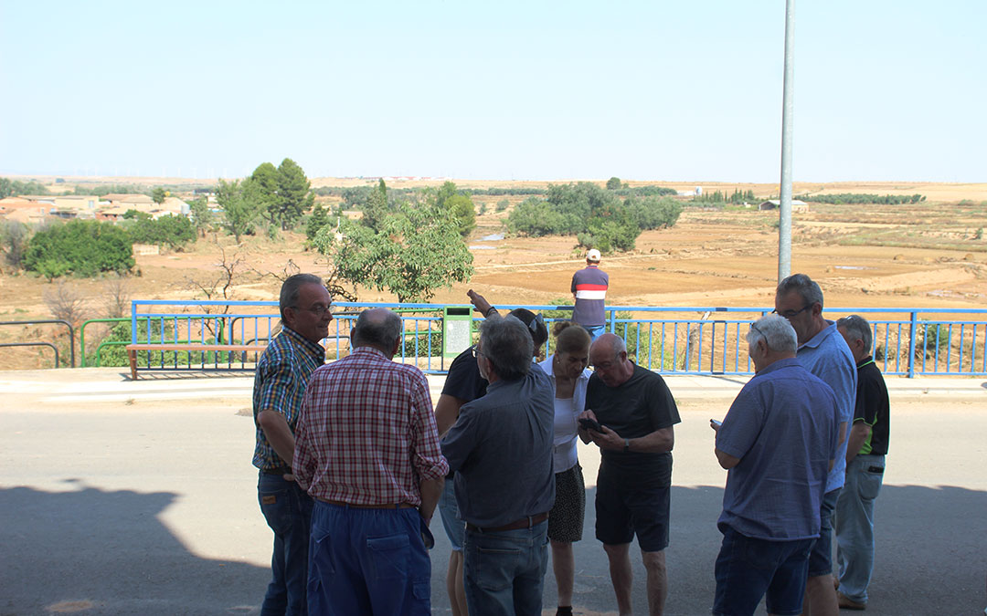 Vecinos comentando la situación en las puertas del ayuntamiento con el río de fondo. / B. Severino