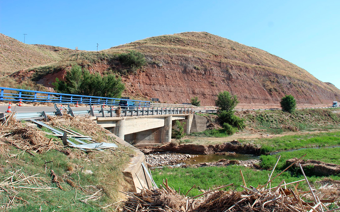 Más de un mes después de la riada que desbordó el río Aguasvivas, en el puente de Azaila todavía se puede ver maleza y solo uno de los carriles está abierto al tráfico. / Beatriz Severino