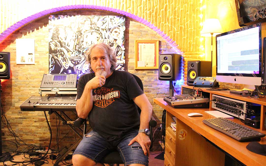 Ernesto López en su guarida estudio donde hace sus composiciones, además de montajes de vídeos que graba. Está flanqueado por un cuadro que pintó Álex Mirasol en tiempo real en un concierto de La Deluxe. De otra pared pende el cartel del documental que Roberto Morote hizo sobre la banda y que puede verse en internet./ B. Severino.