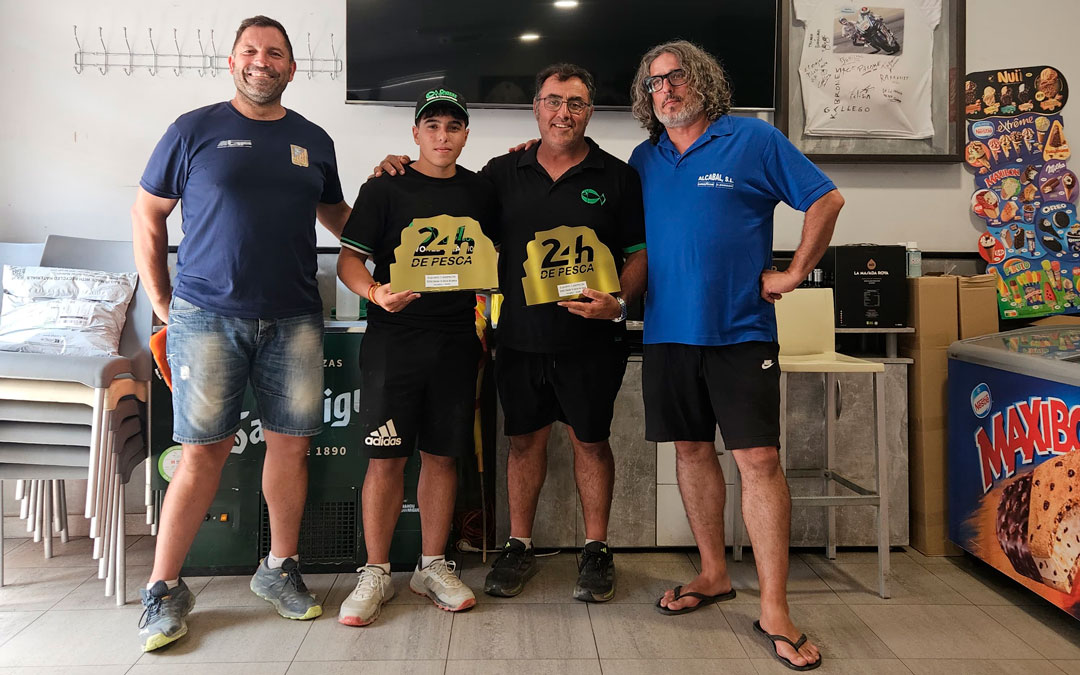 Iker Martín, de diecisiete años, y Ángel Guiu, de cuarenta y nueve, posan con los galardones del torneo de pesca/Alberto Quílez