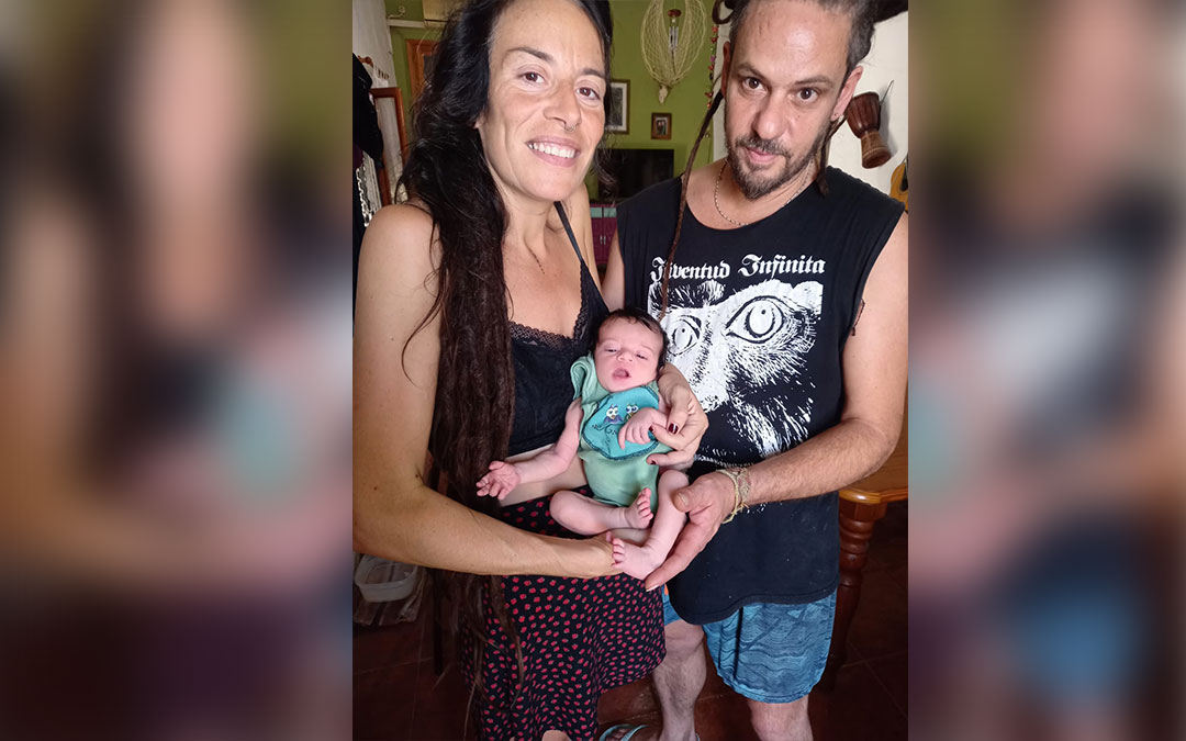 María Carreras y Sebastián Amerio sujetan a su hija Lola, nueva jatielina retratada por su abuelo cuando apenas tenía una semana de vida. / Archivo familiar