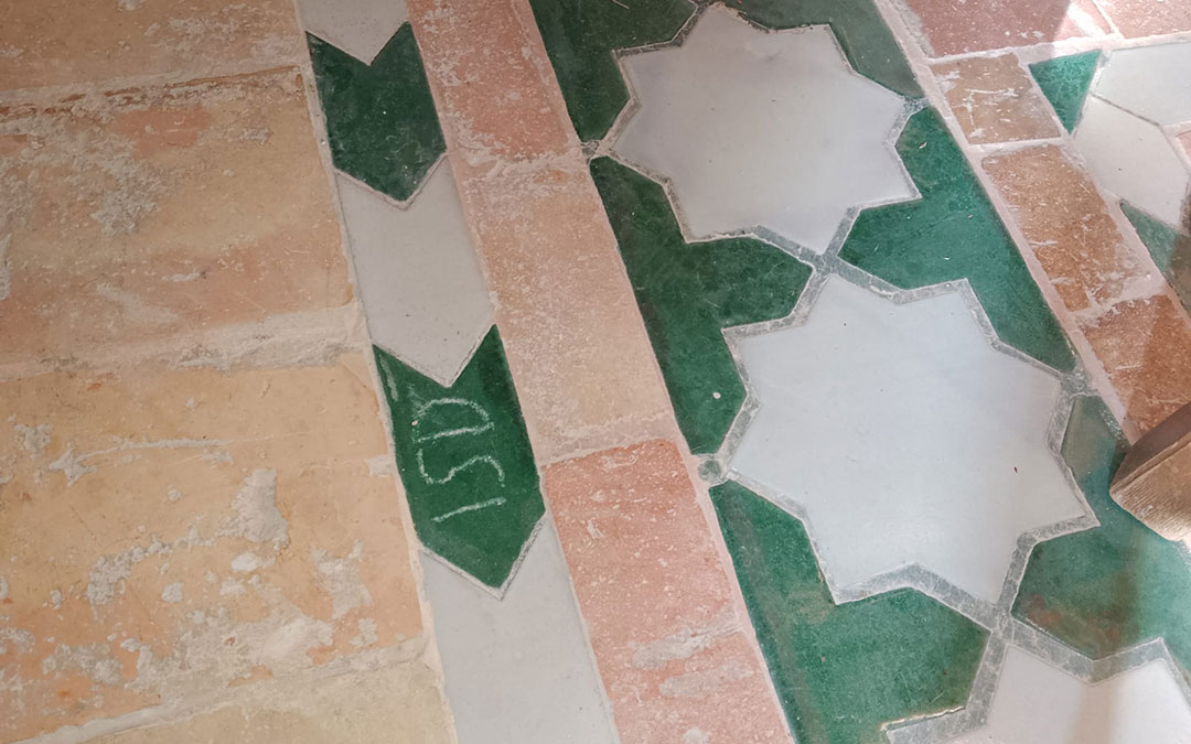 Las tres letras grabadas con un objeto punzante en un azulejo de la sala recién restaurada y ya visitable. / Albalate Turístico