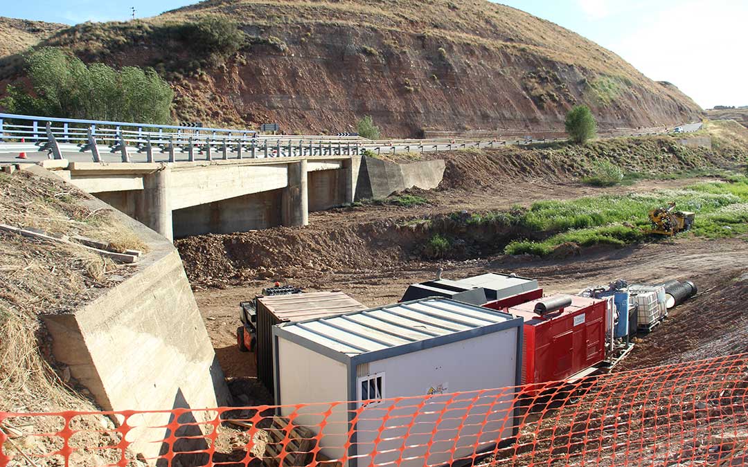 Parte del material, maquinaria y caseta de obra aguarda a orillas del Aguasvivas bajo el puente de la N-232 en Azaila. / B. Severino