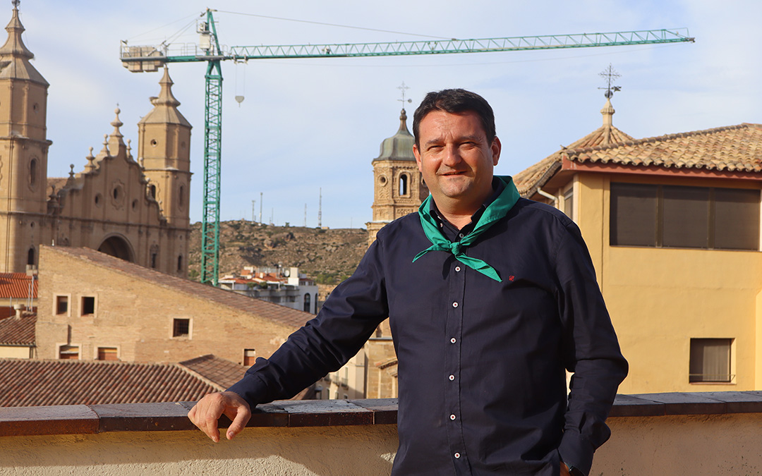 Miguel Ángel Estevan con el pañuelo de la Peña Taurina, de la que es socio. De fondo la grúa de la plaza que ha obligado a cambiar la ubicación de actos. / A.Z