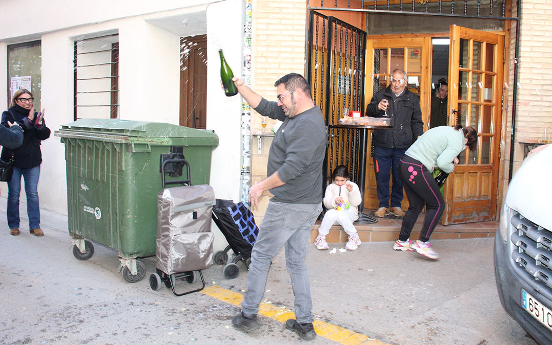 Juan Carlos Elías descorchando el cava. Se desata la locura en Albalate del Arzobispo con el 23112, primer quinto premio, vendido por Pescados Elías. / B. Severino